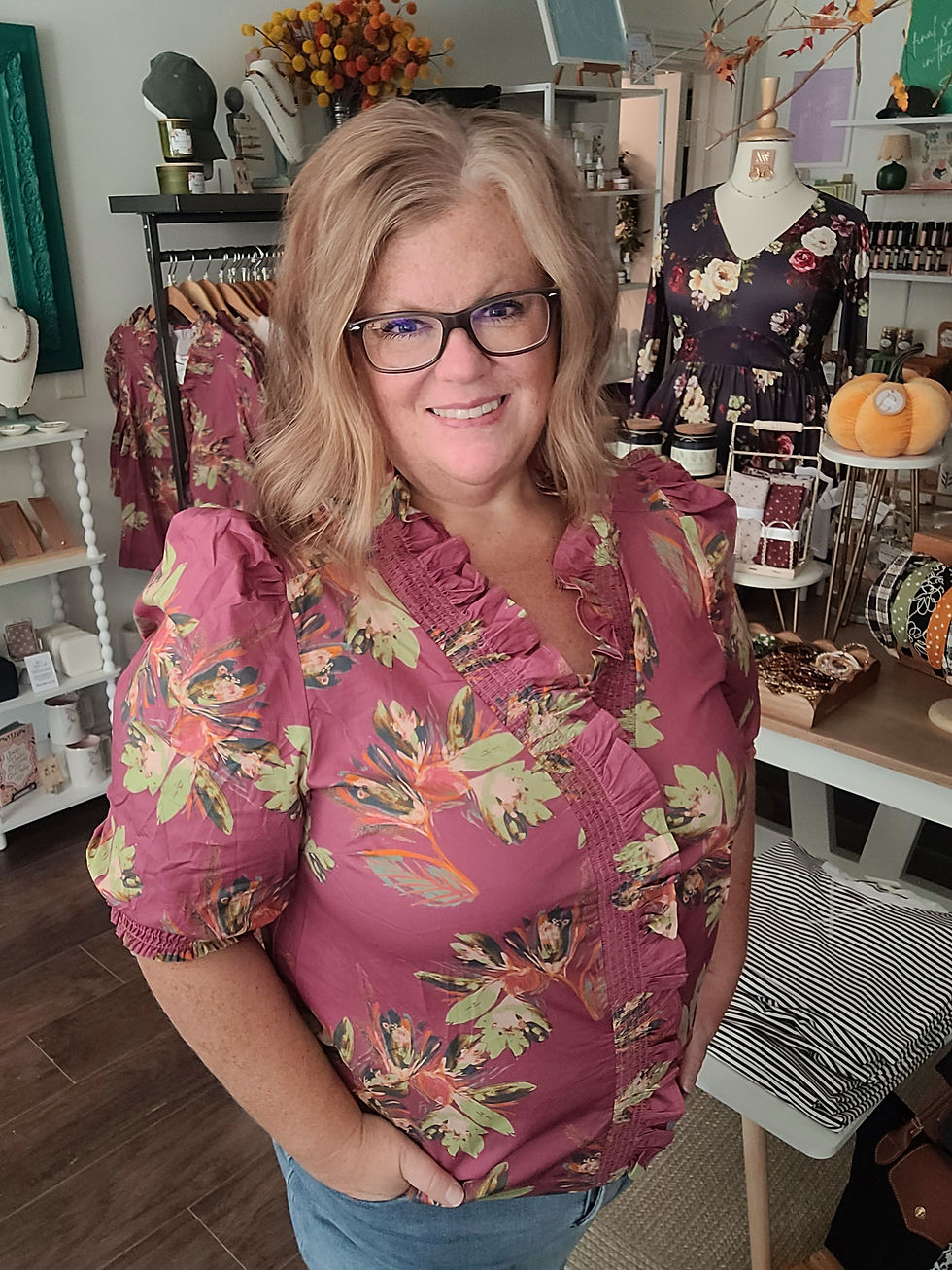 Mauve floral print blouse with ruffled V-neck and puff sleeves, modeled against a neutral background