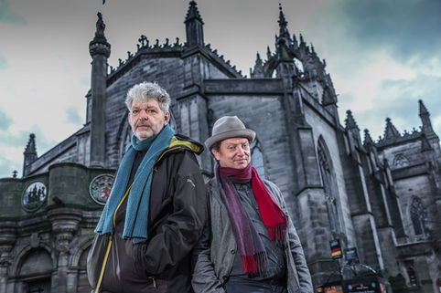 Two men stand in front of St Giles Cathedral in Edinburgh old town