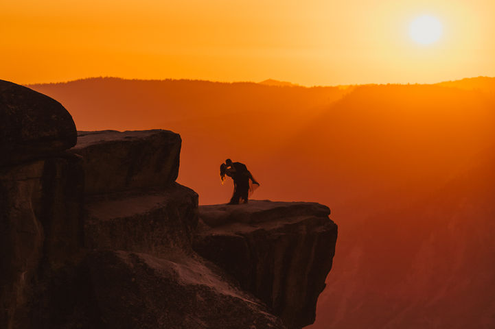 warm golden hour at taft point, yosemite, ca. couple is dipping and kissing on an adventure session by gianna christina photo