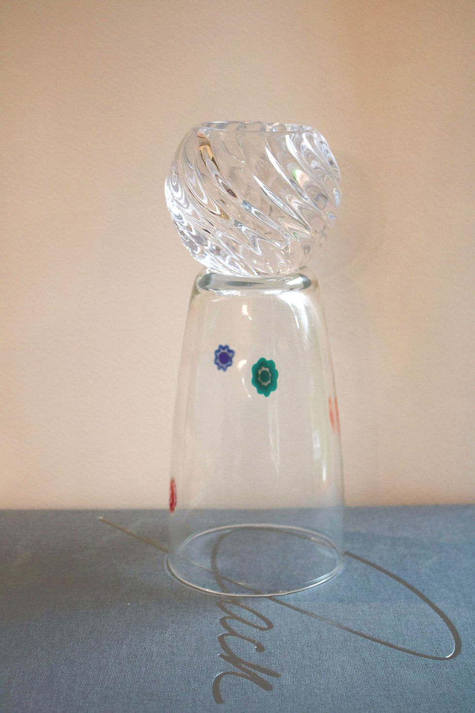 Murano-style millefiori tumbler with colorful flower inlays stacked with ribbed clear swirl glass bowl