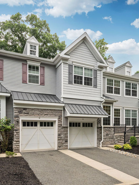 Front exterior of renovated townhouse at 20 Masterson Court in Waldwick NJ featuring landscaped grounds, attached garage, and modern farmhouse-style architecture.