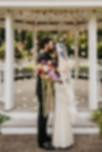 Bride holding colorful bouquet stands with groom. Wedding in Portland, Oregon filled with colorful florals.
