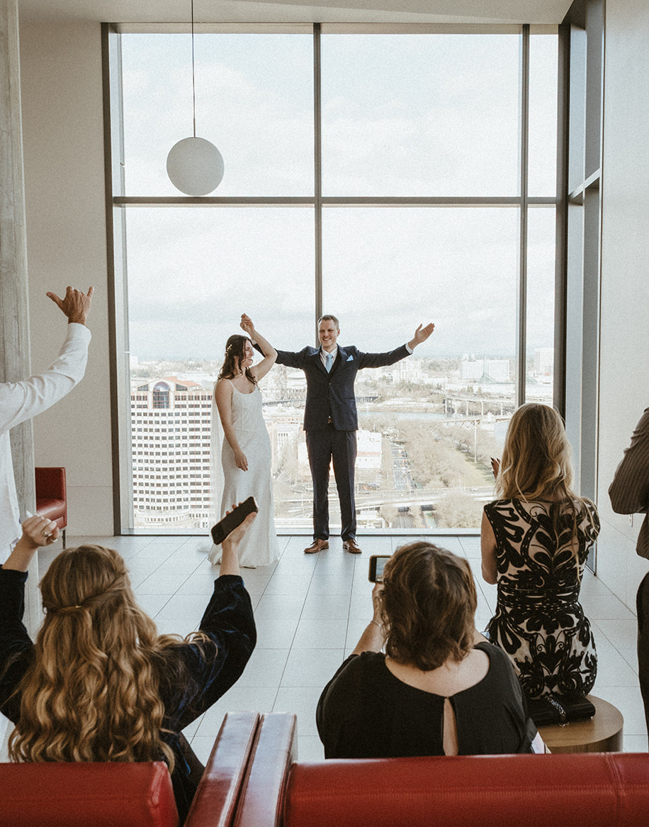 Bride and groom celebrate with guests at their wedding ceremony in the Multnomah County Courthouse in Portland, Oregon.