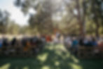 Wedding ceremony takes place in the shade of a tree at Mt. Pisgah in Eugene, Oregon.
