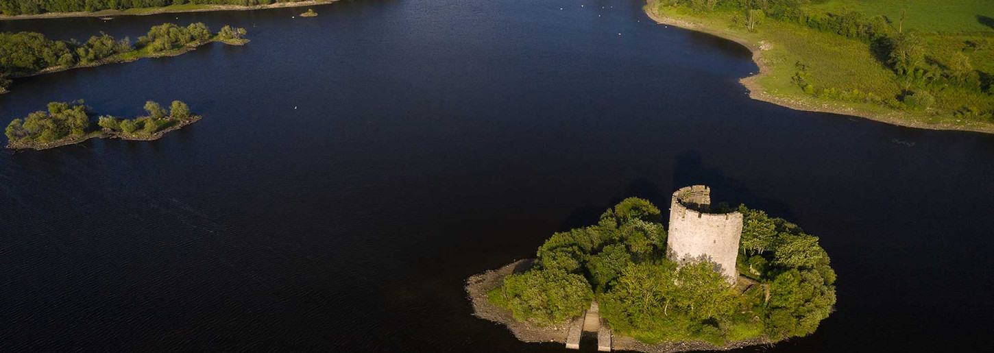 Ruined castle on green island in lake, aerial view. Bed and Breakfast Cavan.