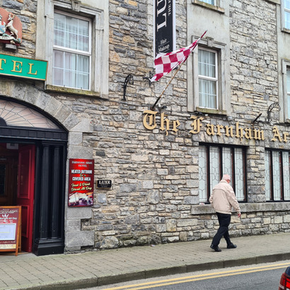 Stone building 'THE SLANE' HOTEL, person walking past, street scene.