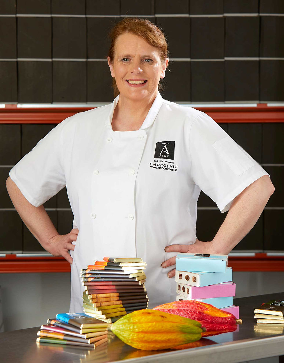 Ann Rudden smiling behind a table of her award winning chocolate