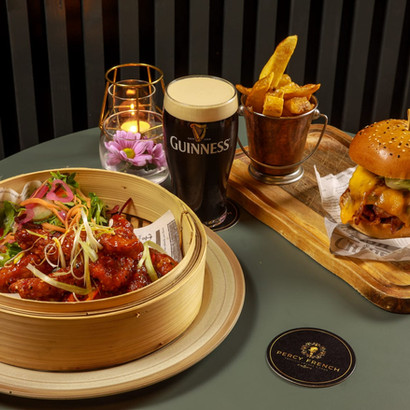 A delicious burger, chicken dish, golden fries, and GUINNESS pint.