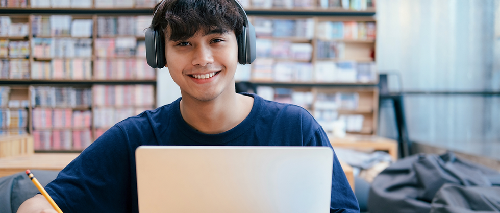 Smiling male student with dark hair wearing blue shirt and headphones