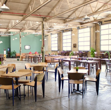 Enlightened Brewery dining room, tables and chair, green wall, big windows