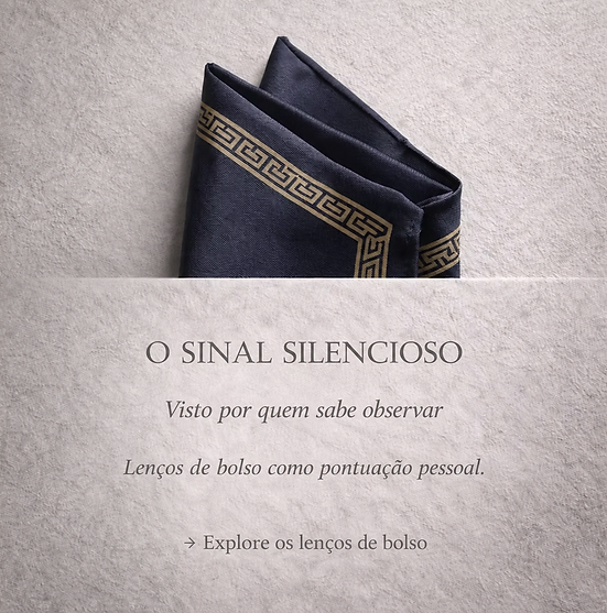 Lenço de bolso em seda azul-marinho com borda geométrica dourada, elegantemente dobrado sobre um fundo de textura suave.