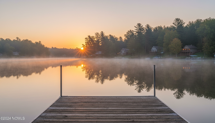 Wide-angle view of a quiet Steuben County lake at sunrise.
