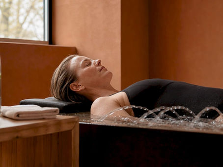 En kvinde nyder en afslappende hydromassage og lader sig forkæle i spaens rolige omgivelser.
