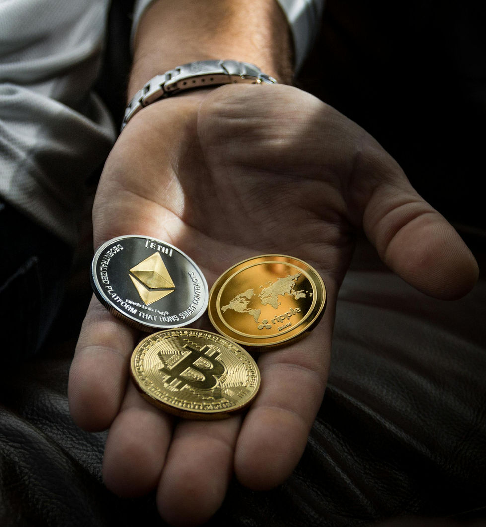 Hand holding Bitcoin, Ethereum, and Litecoin coins representing cryptocurrency, blockchain, and digital finance investment.