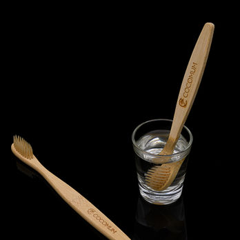 Eco-friendly neem toothbrush placed on a natural jute fabric background for lifestyle product photography