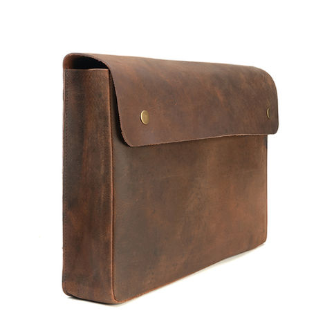Brown leather case with snap closure showing natural grain texture — luxury leather gift product photography
