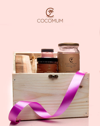 Coconut oil bottle placed beside raw coconut and wooden spoon in a wellness-themed product shoot