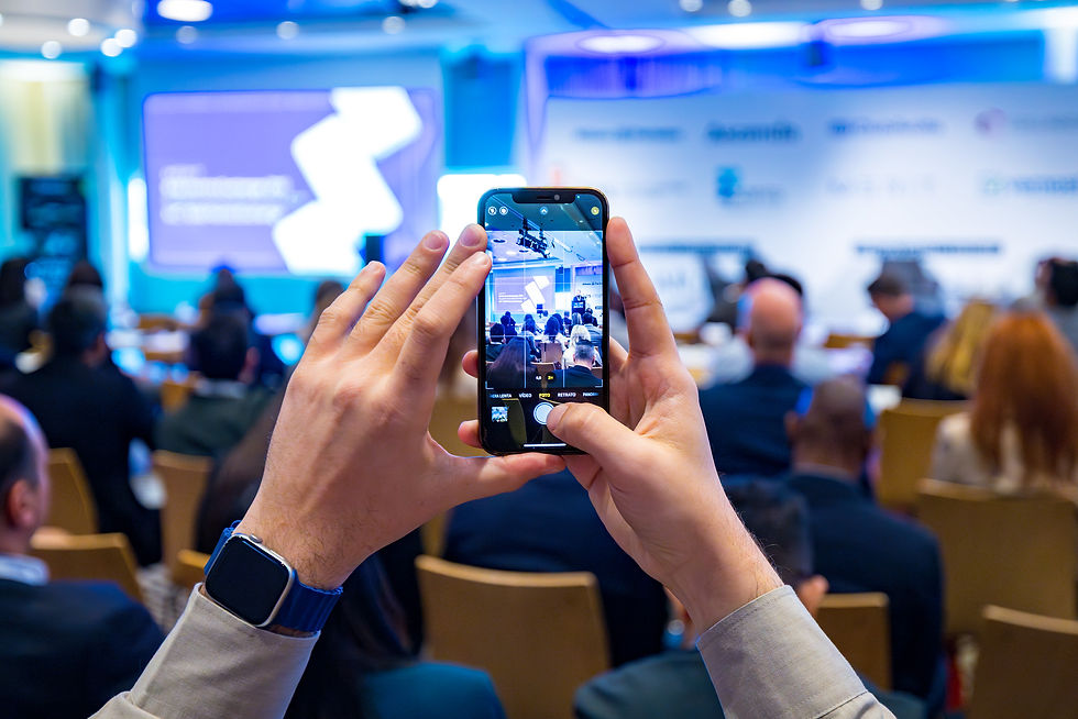Congresbezoeker fotografeert het podium met zijn telefoon om het meteen te delen