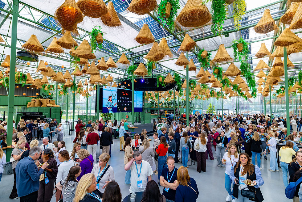 Gasten in de Evenementenkas van de Midden Nederland Hallen onder hangende planten en een glazen dak