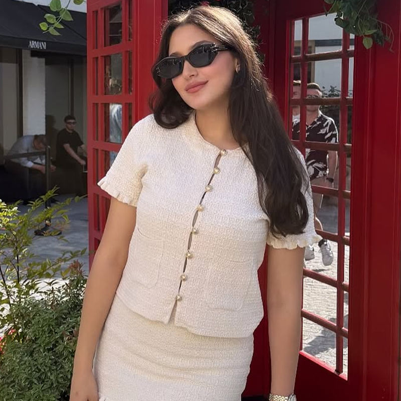 Thumbnail: Woman in a cropped knit cardigan and sunglasses