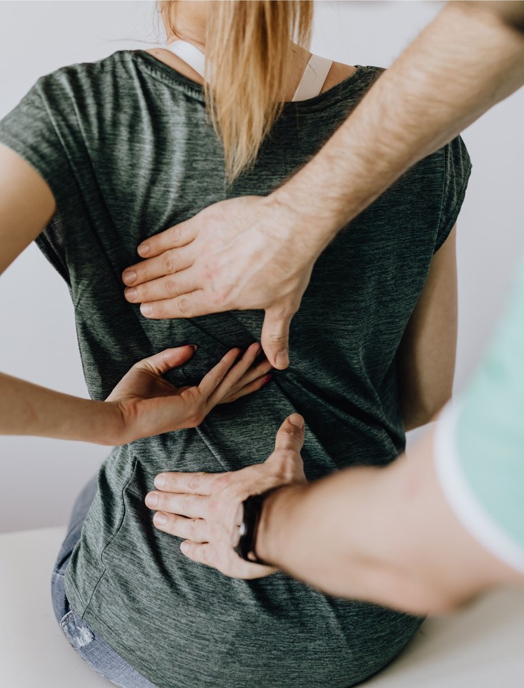 Osteópata valorando la espalda de una paciente sentada