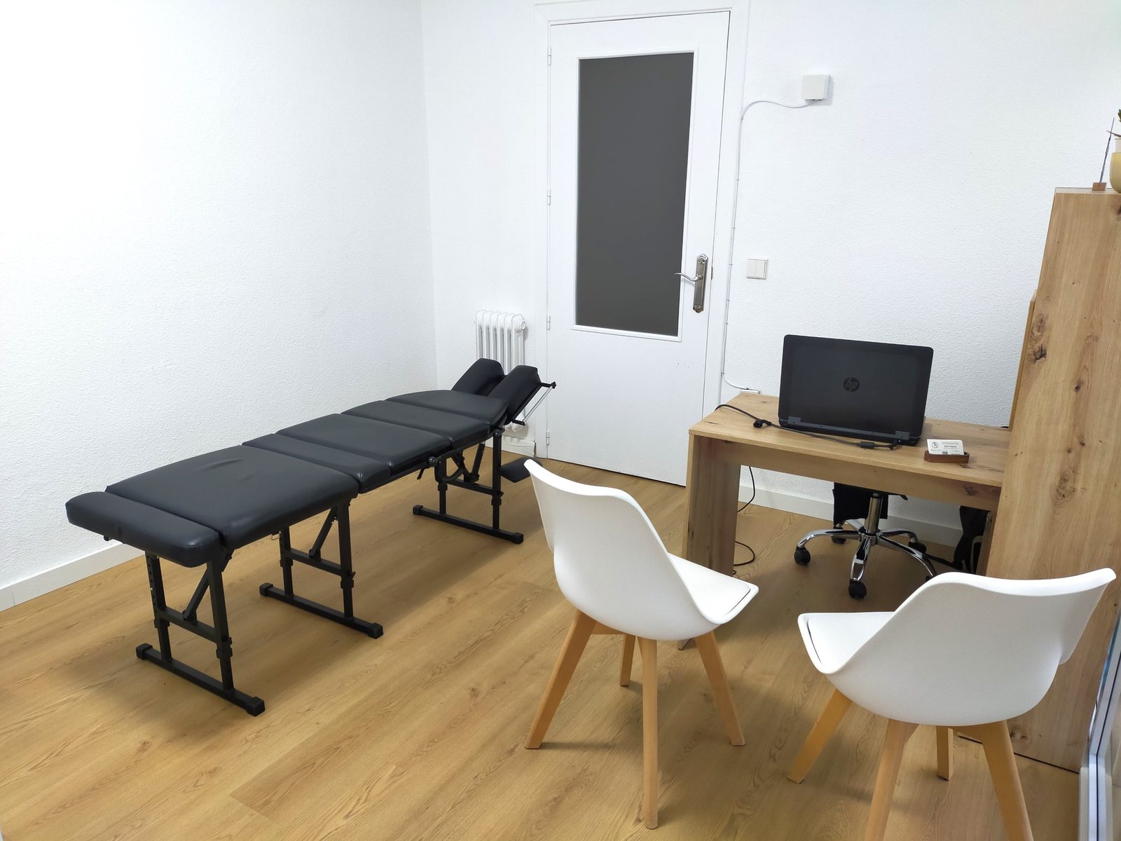 Sala de tratamiento de la consulta de osteopatía de Alex Taquoi en Ciudad Real, con camilla y mesa de trabajo