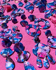 a group of purple blue and pink earrings