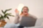 Medium shot smiley woman with headphones using laptop for online therapy.webp