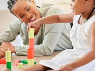 Parent and child engage in a playful session using colorful blocks, illustrating effective strategies of ABA therapy that dispel common myths for parents in Stafford by 2026.