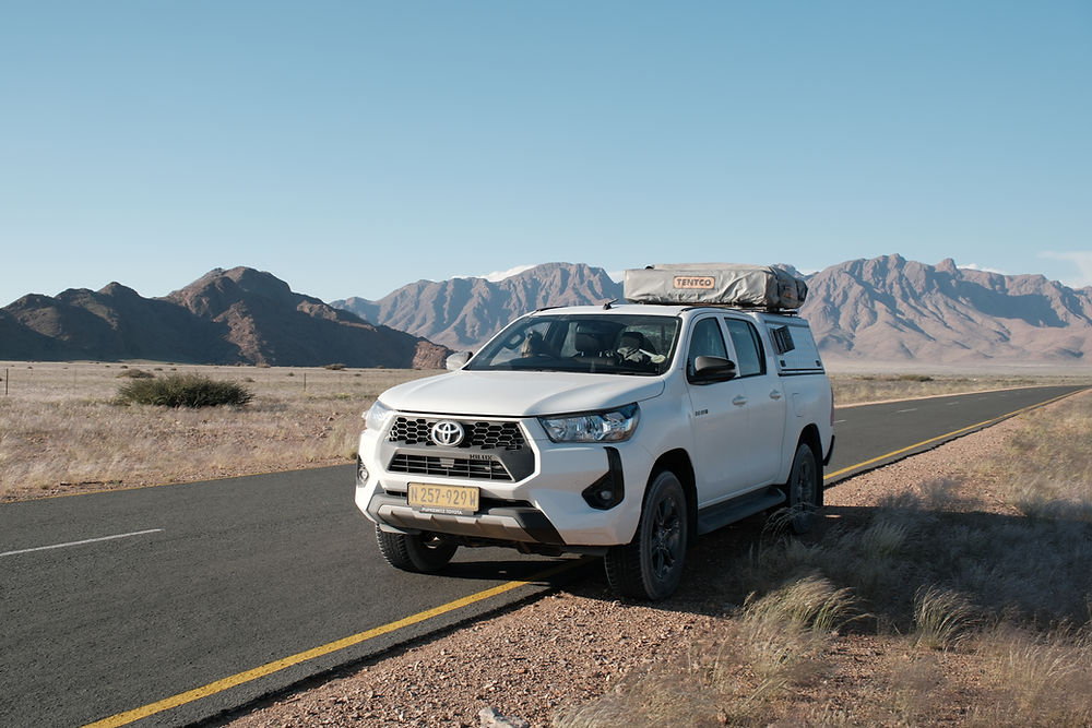 White pickup truck on a desert road for Advanced Car Hire