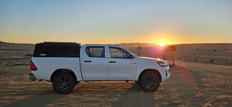 White pickup truck in desert at sunset