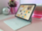 Purple iPad Air 11 inch M2 attached to the white Apple Magic Keyboard sitting on top of a desk.