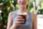A person holding a smoothie with a paper straw, emphasizing eco and gluten-free lifestyle