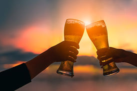 couple-hands-holding-beer-gass-clanging-bar-summer-sunset.jpg