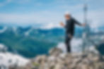 Bergsteiger isst Kantonsgipfeli auf Berggipfel mit Aussicht
