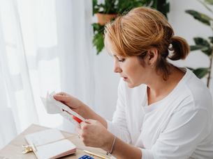 Small business owner reviewing financial and tax documents at a desk while managing bookkeeping and accounting records