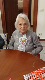 Giovanna seduta a tavola mostra il suo lavoro