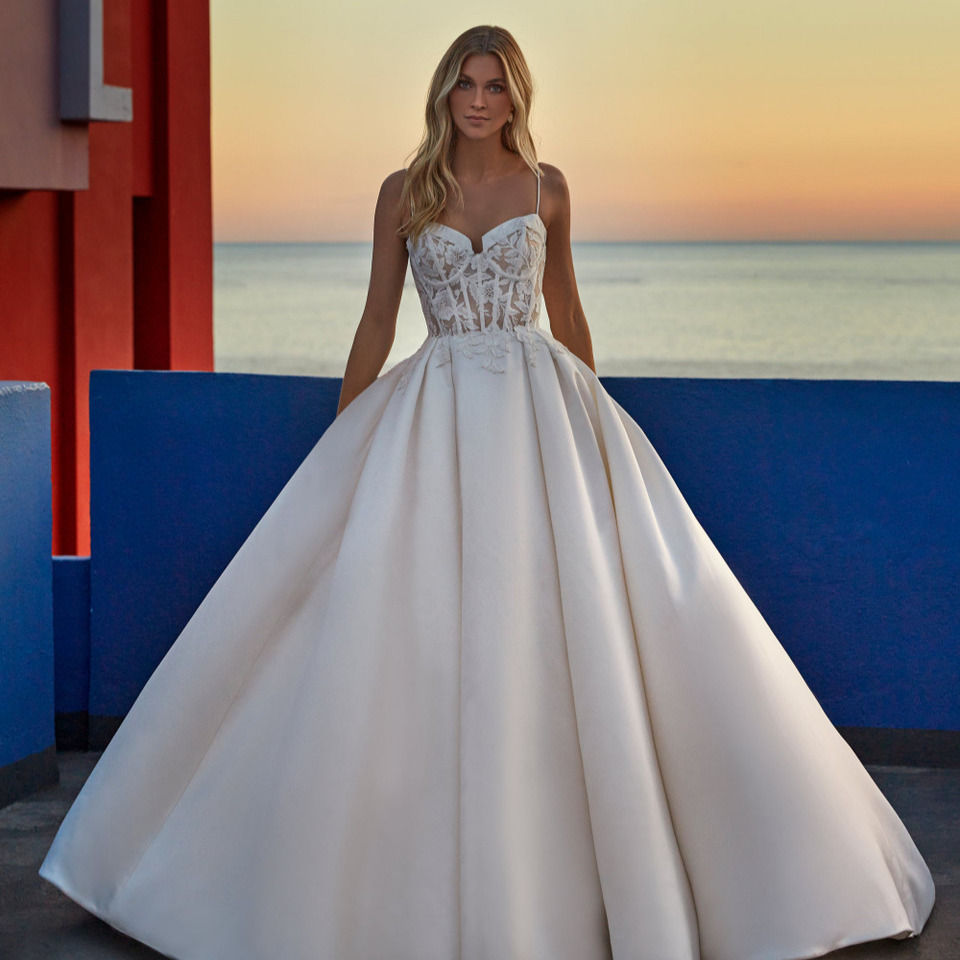 Girl modeling a ballgown wedding dress with plain skirt and lace structured bodice