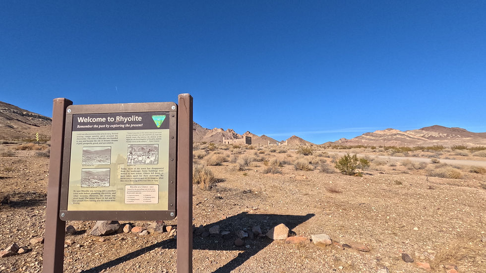 Welcome to Rhyolite sign with ruins in the distance