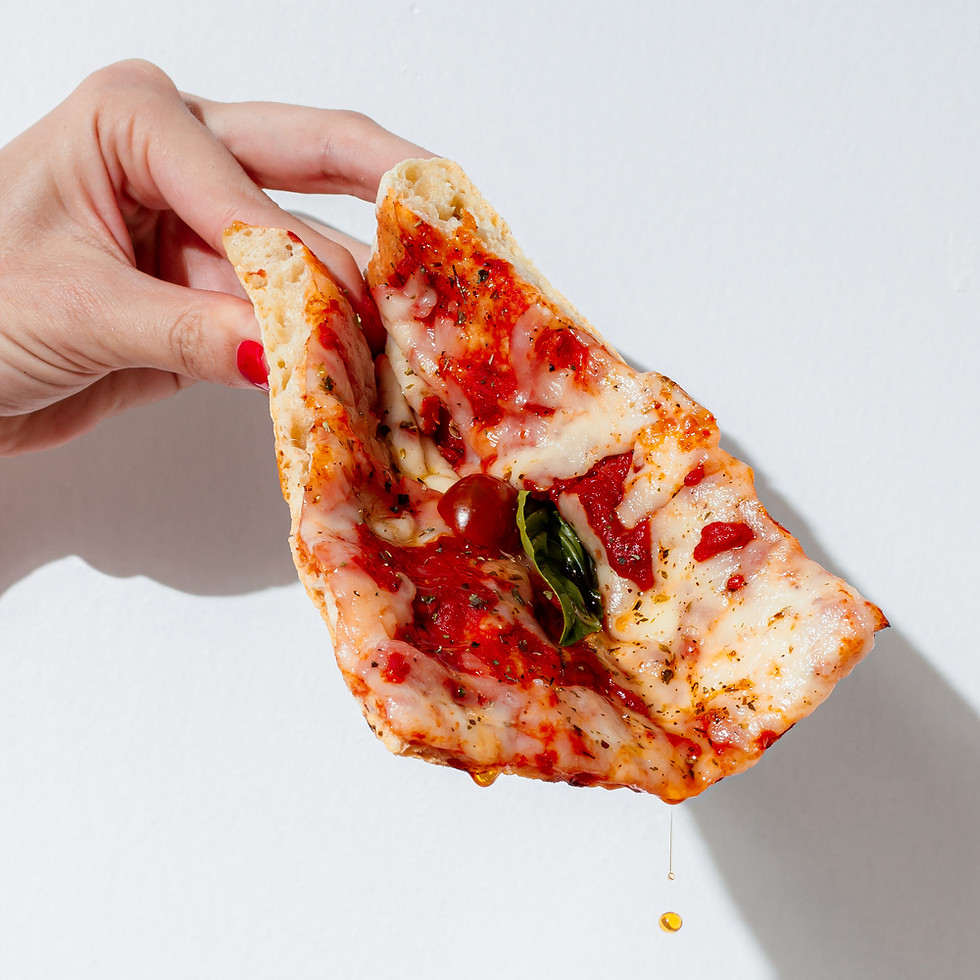 Hand holding a slice of pizza