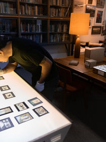Researcher examining lantern slides in the Archives and Special Collections library at The Whyte in Banff, Alberta.