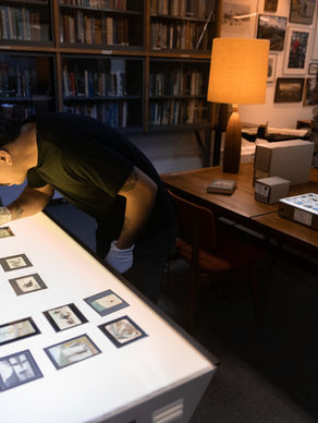 Researcher examining lantern slides in the Archives and Special Collections library at The Whyte in Banff, Alberta.