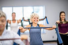 Smiling woman in fitness class using resistance bands