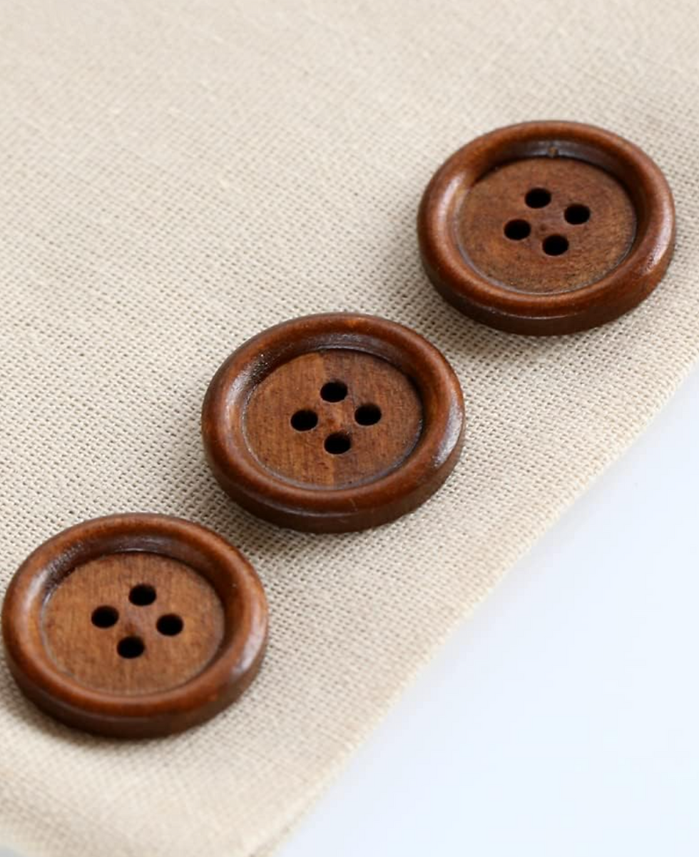 Miniatura: 3 wooden buttons on a beige cloth