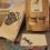 Thumbnail: Knitting Bag, Knit frog in paper bag, White Zipper pouch, Llama tape measure, Point protectors, Scissors, Wood Butterfly magnet needle holder, Silicone stitch saver