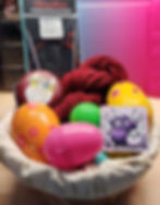 Basket with Easter Eggs, red yarn, Measuring tape, Purls n' Potions magnet, Red Lace Chia Goo Knitting Needle