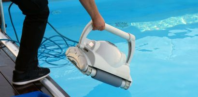 Professional technician cleaning and maintaining automatic robotic pool cleaner equipment