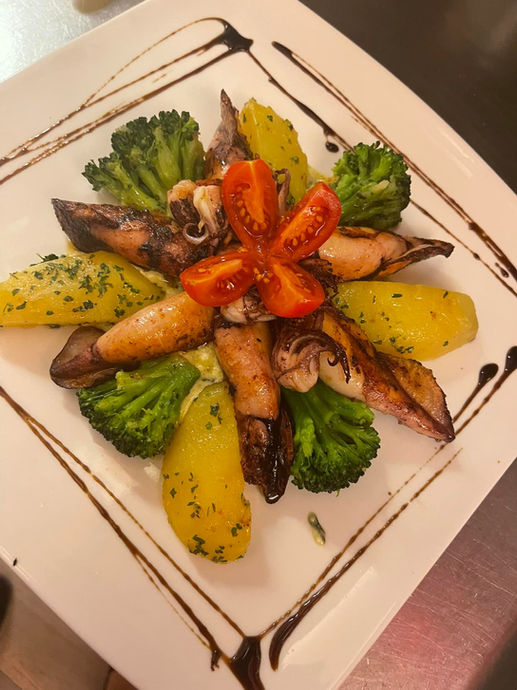 Calamari auf Spinatsauce und Grill Kartoffeln nach art des Hauses