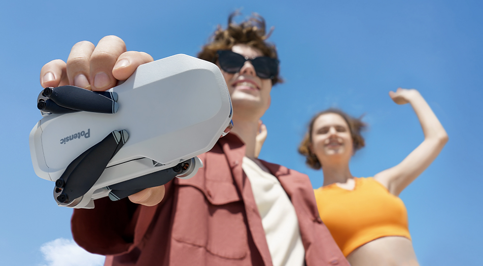 A guy in the background holding a drone in the camera