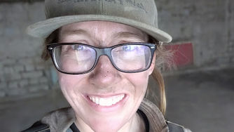 woman with ball cap and glasses smiling